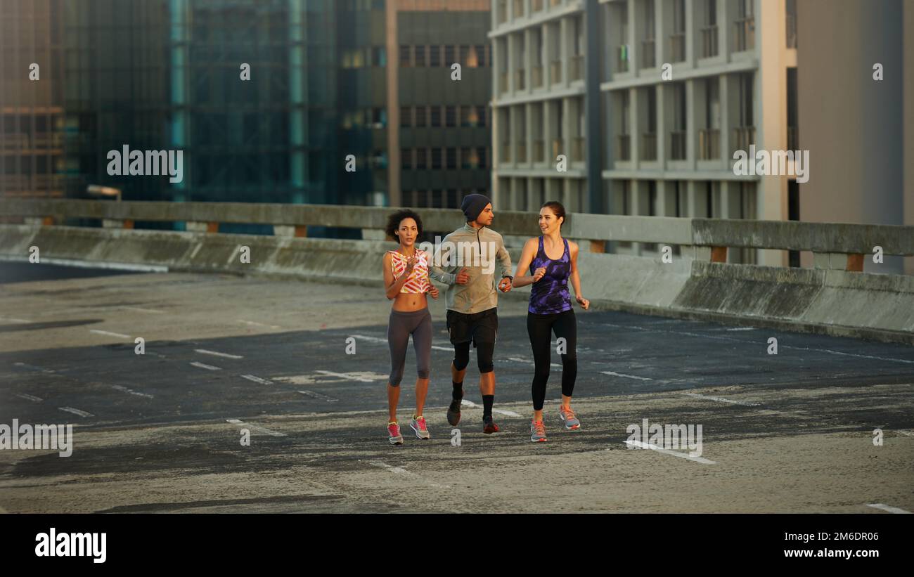 Nothing but us and the road. joggers running down an empty highway in the morning. Stock Photo