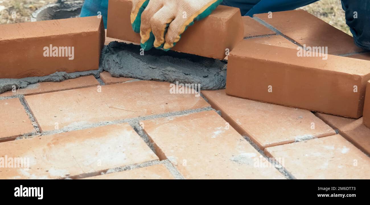 A man builds a brick wall. Brick put on the solution. Construction of