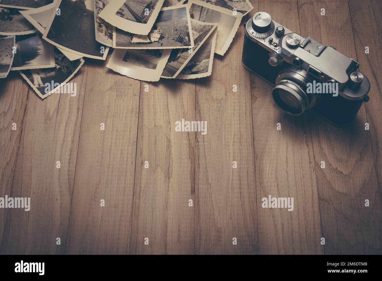 Vintage photo camera with old photos. Stock Photo