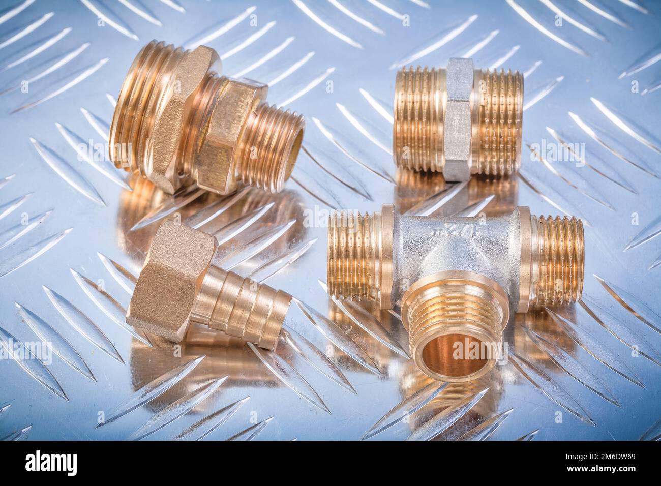 Brass nipple hose connectors equal tee on grooved metal background