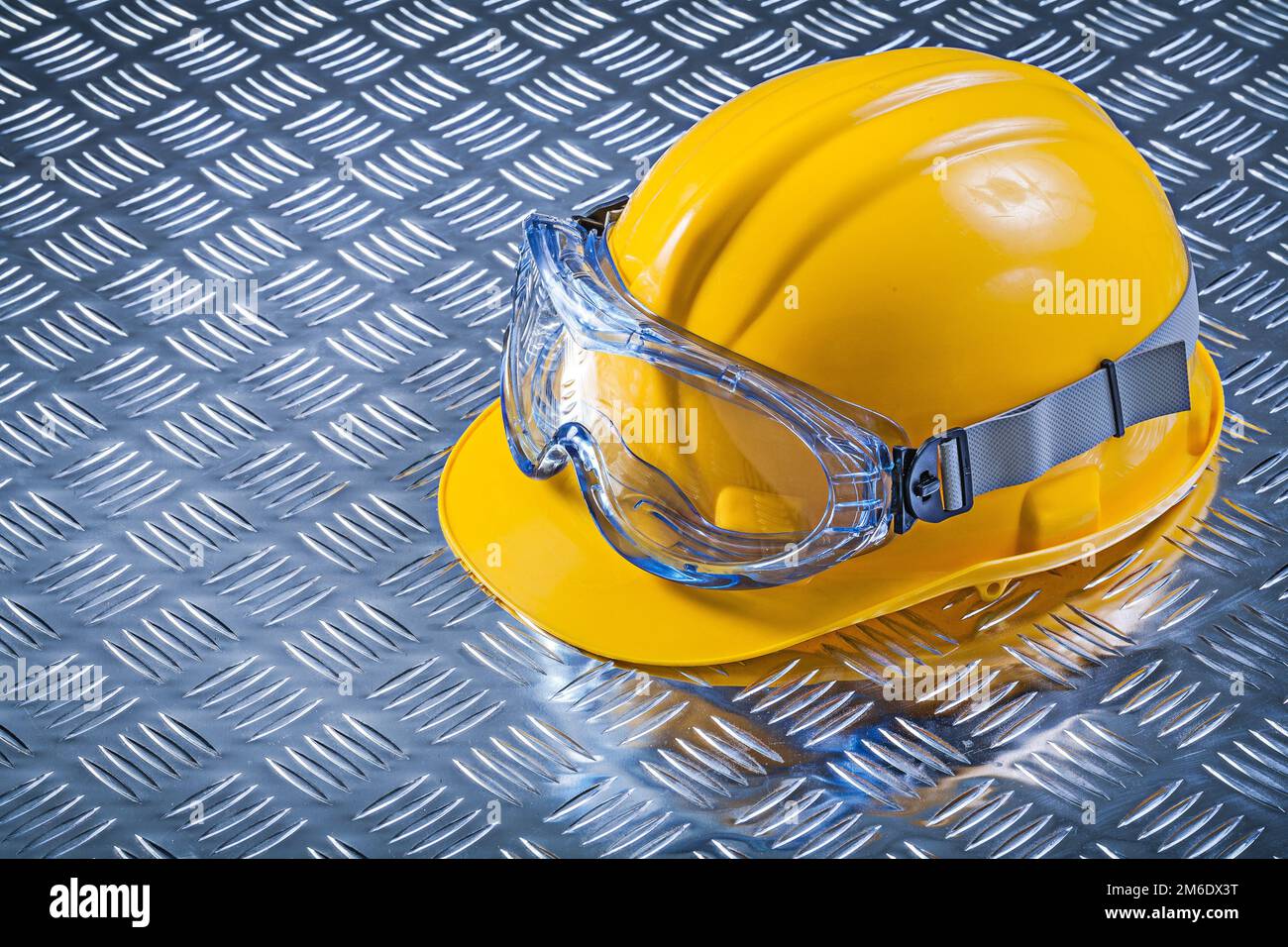 Goggles hard hat on fluted metal background construction concept Stock