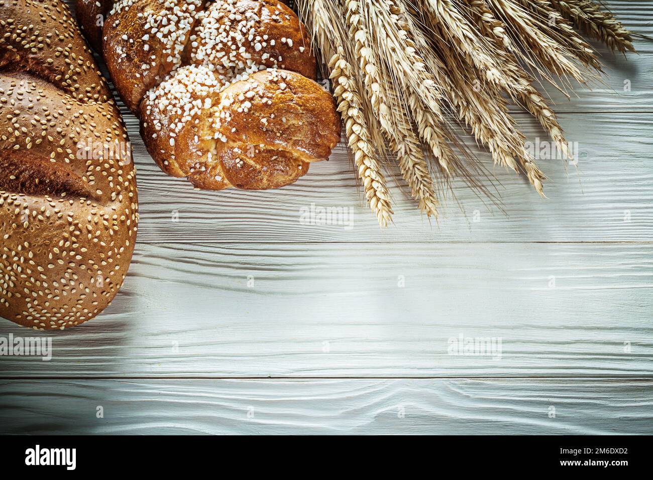 Loaf of bread wheat ears on white board Stock Photo - Alamy