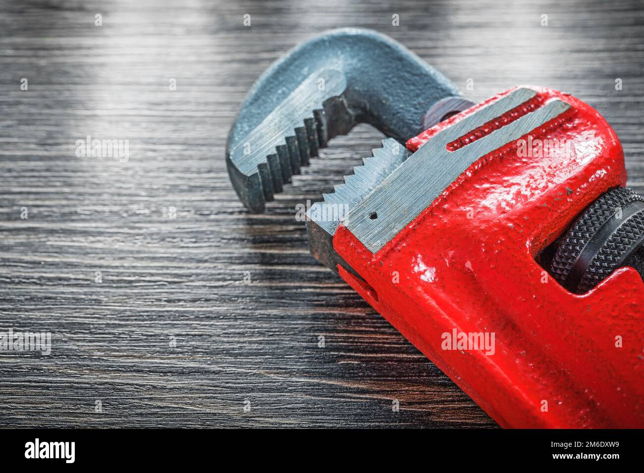 Plumbing adjustable wrench on vintage wooden board. Stock Photo