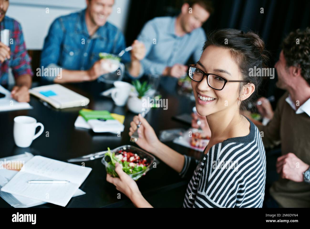 Enjoying lunch with the team. Portrait of a young office worker eating