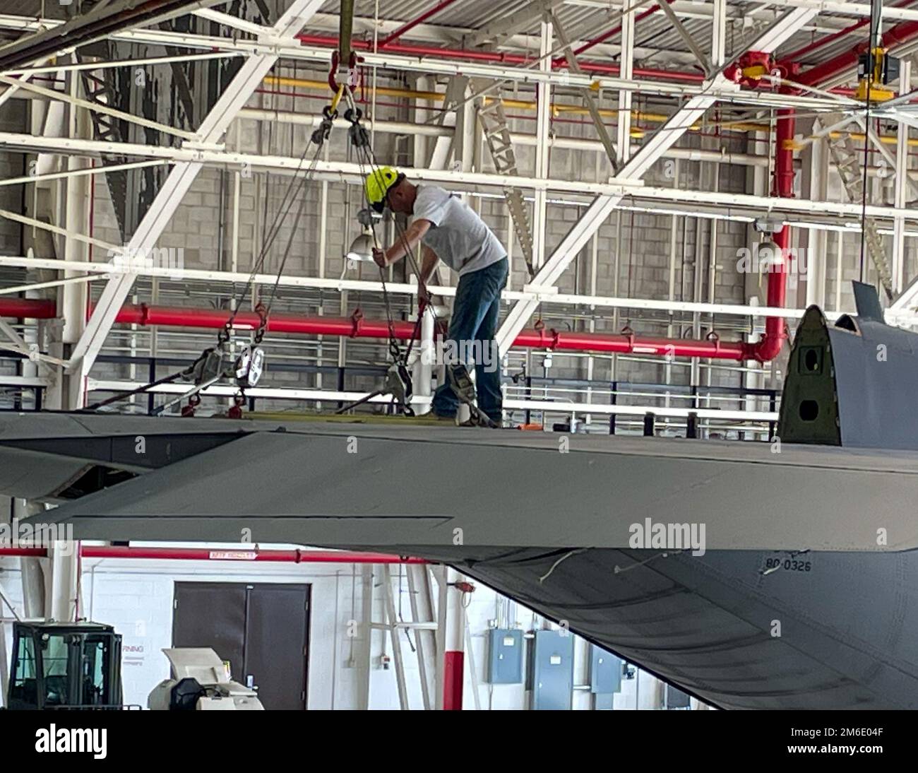 A contractor tightens up the cable attached to the tail section of a C-130H Hercules transport plane in its hangar prior to removal April 25, 2022 at Niagara Falls Air Reserve Station, New York. Other main parts such as the wings will be removed in order so the plane may be transported to its static display location on base. Stock Photo