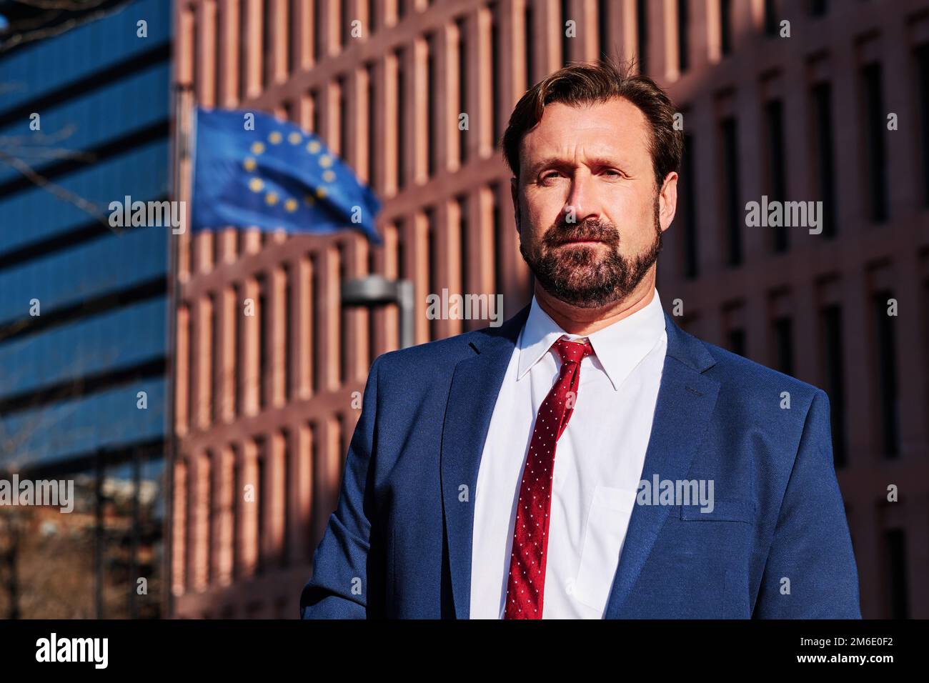 Powerful businessman next to a building with the european flag Stock Photo