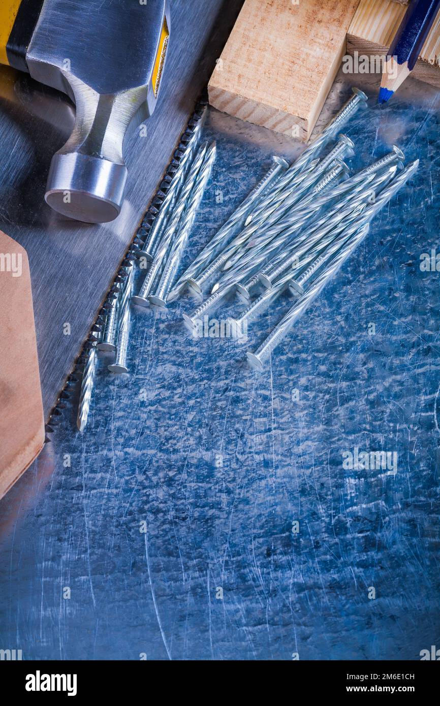 Construction nails claw hammer wooden bricks hand saw pencil on