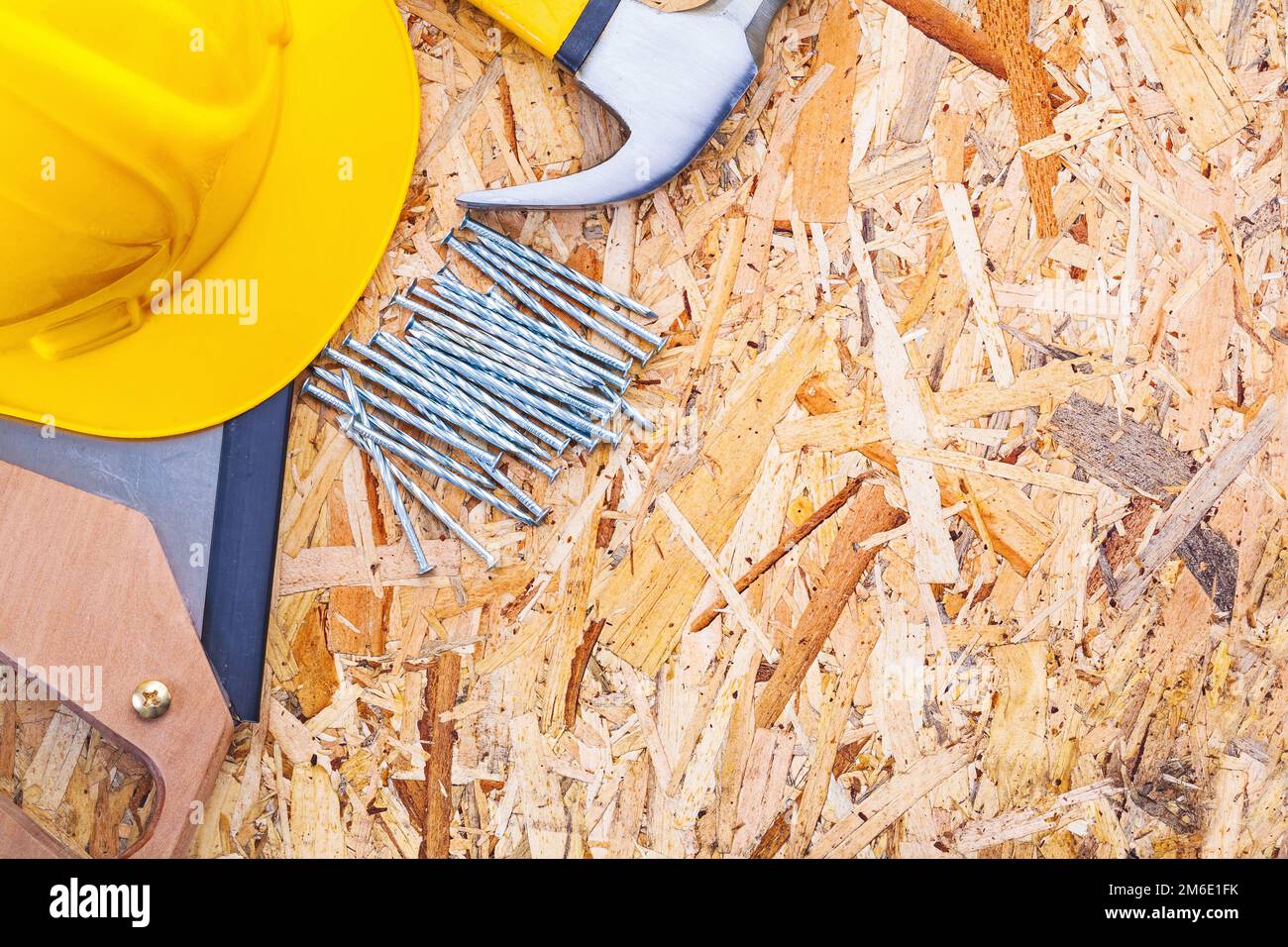 construction tools helmet handsaw claw hammer nails on plywood