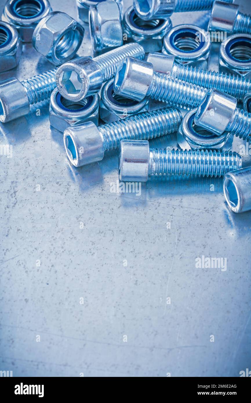 Group of threaded construction nuts and screw bolts on metallic