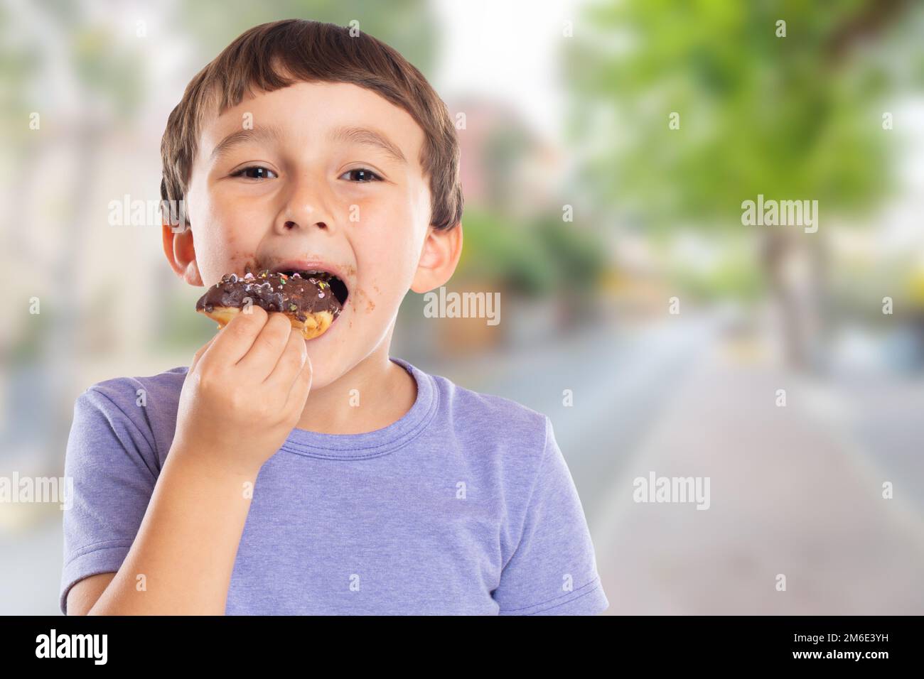 Portrait of a young boy child eating donut town copyspace copy space unhealthy sweet sweets Stock Photo