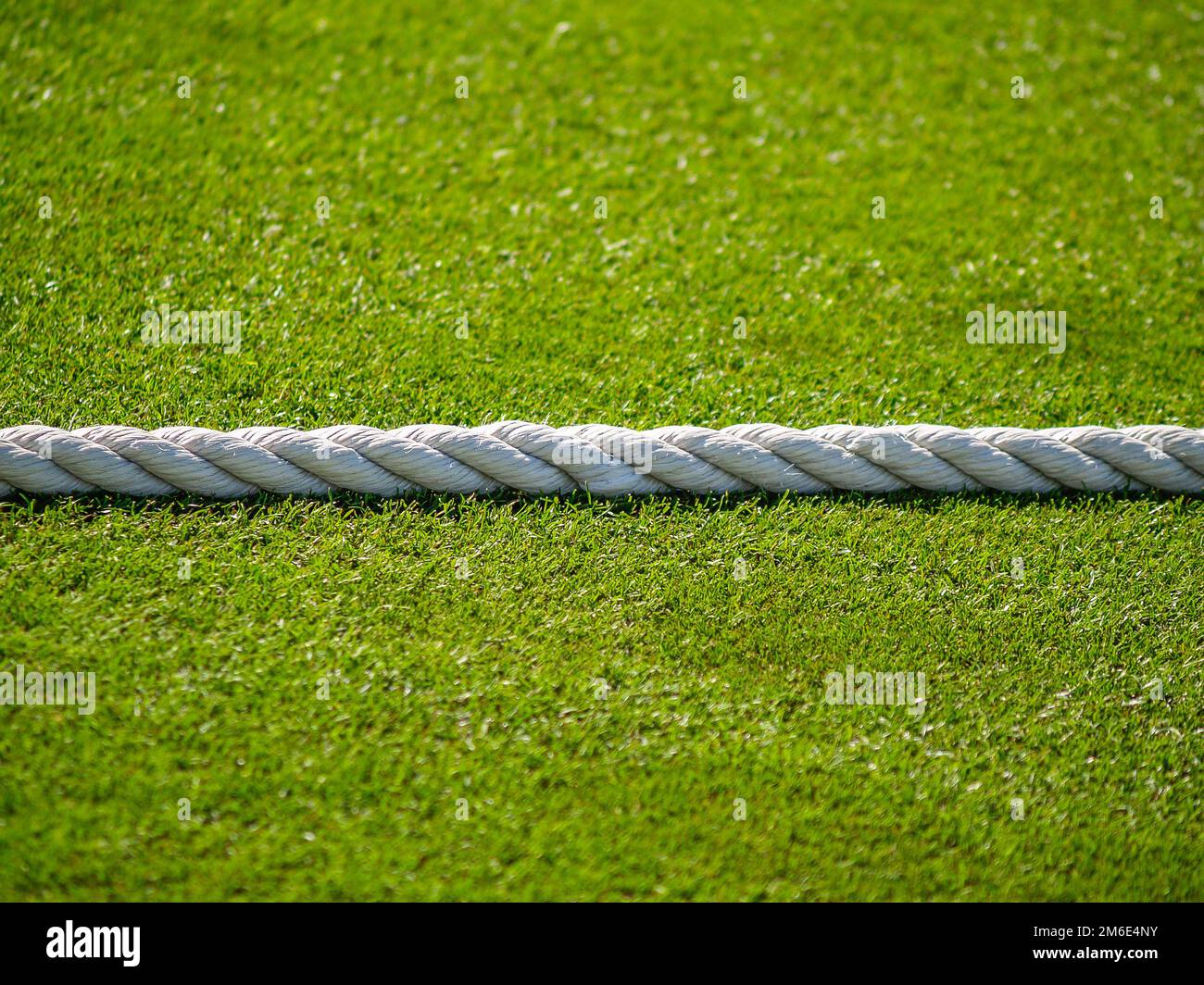 White rope divides green lawn as boundary rope on cricket pitch. Stock Photo