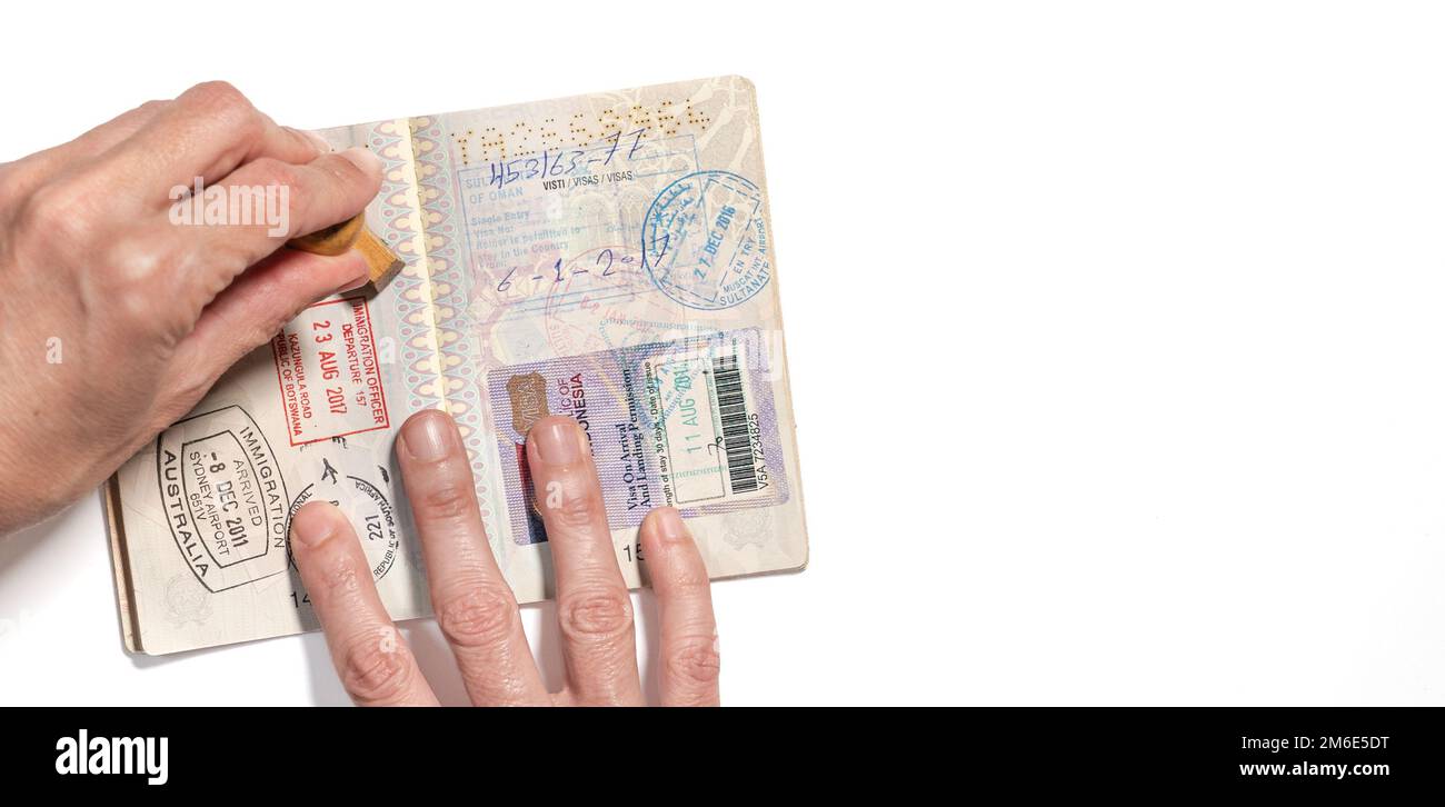 Stamping visa on an Italian passport pages with a lot of visa stamps
