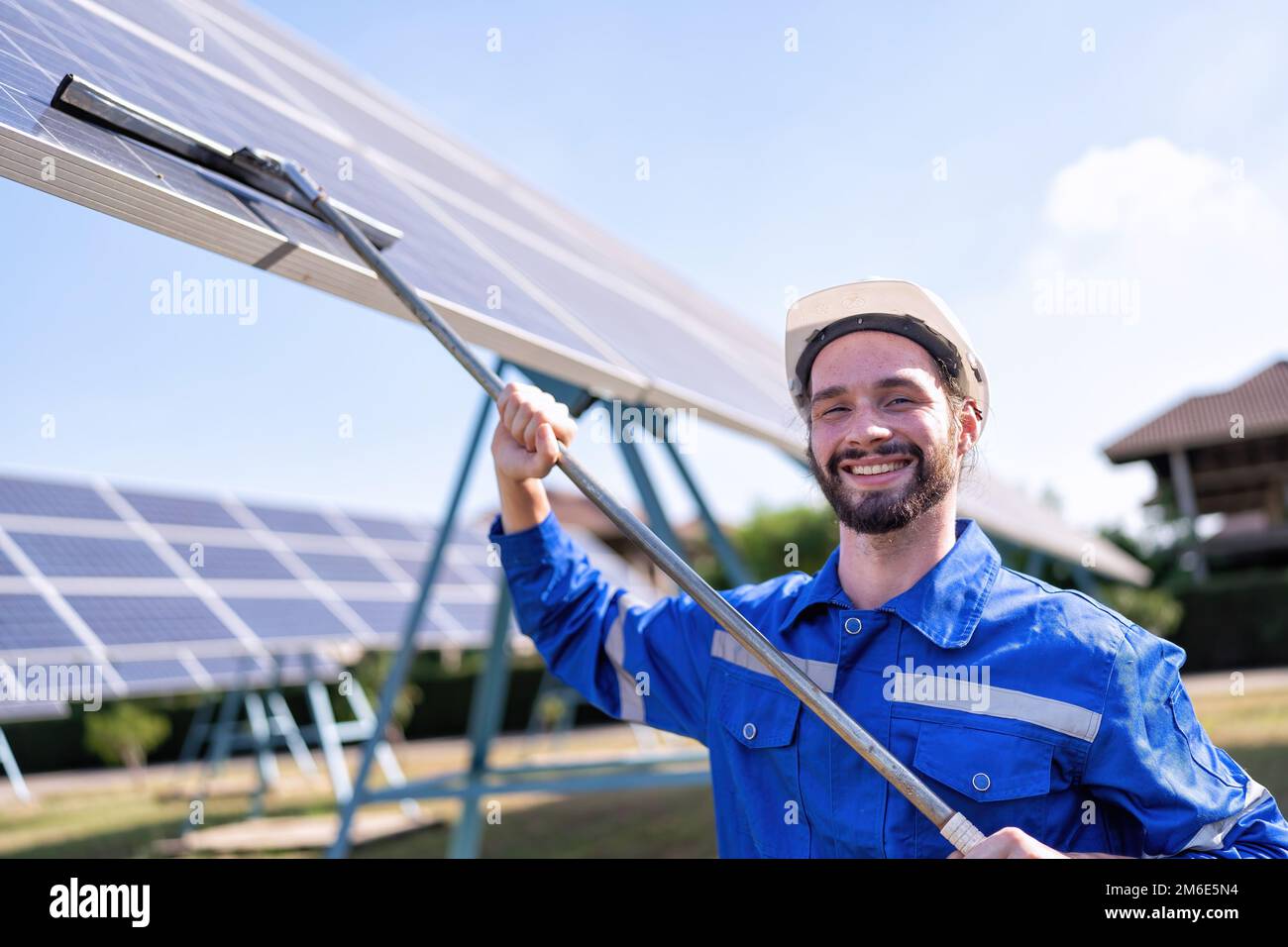 Service engineer use a mop cleaning solar panel for good performance
