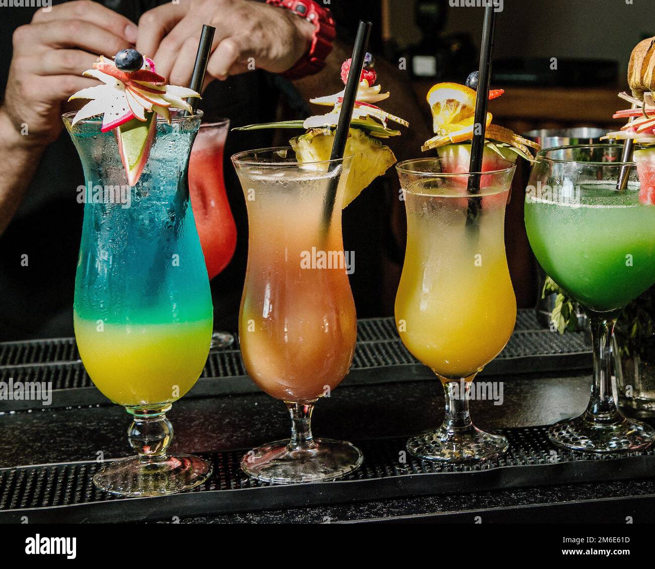 Cocktails drinks on the bar. Alcoholic cocktail row on bar table, colorful party drinks. Stock Photo