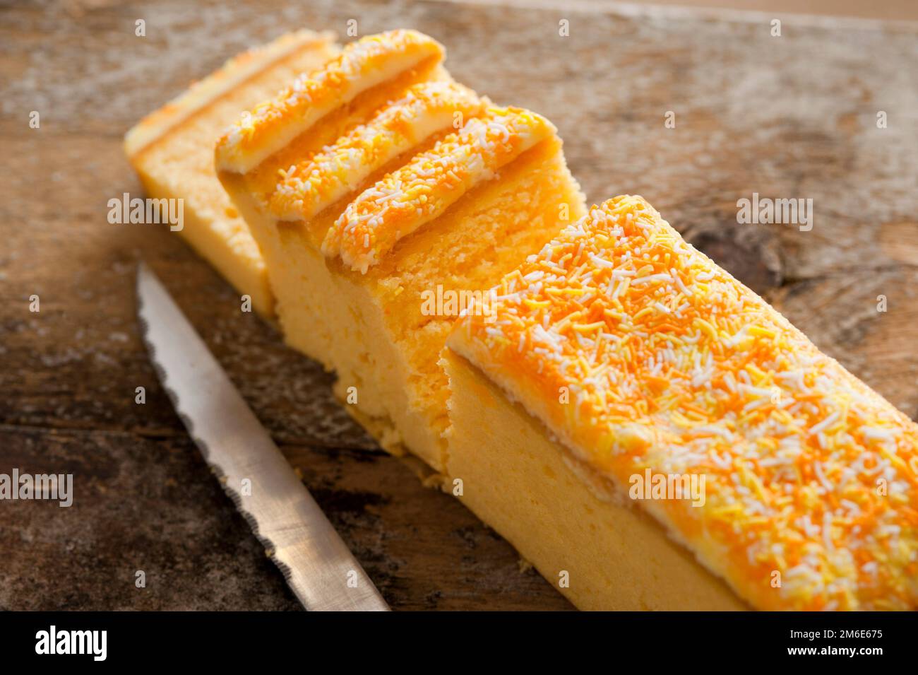 Sliced fresh vanilla sponge cake with icing Stock Photo