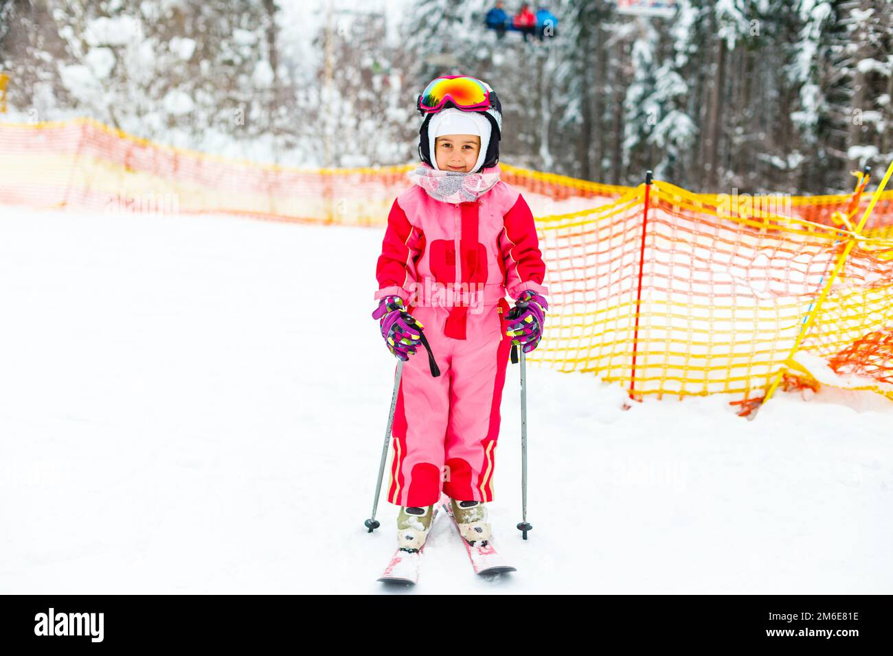Child skiing in mountains. Active toddler kid with safety helmet