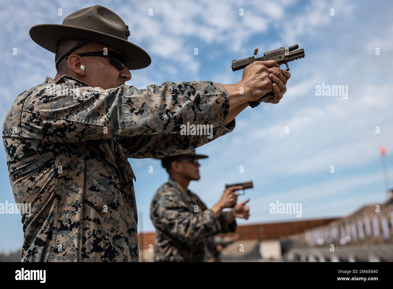 U.S. Marine Corps SSgt Marco Casillas, an instructor for Formal Marksmanship Training Center, Weapons and Field Training Battalion, demonstrates a drill during block three of the Combat Pistol Program (CPP), at Camp Pendleton, California, April 26, 2022. Table one of CPP consists of 5 training blocks and 200 rounds per Marine. Stock Photo