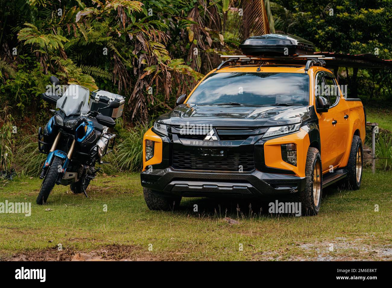 Kuala Tahan, Malaysia - Sept 23, 2022 Mitsubishi compact pickup truck and Super Tenere motorcycle. Stock Photo