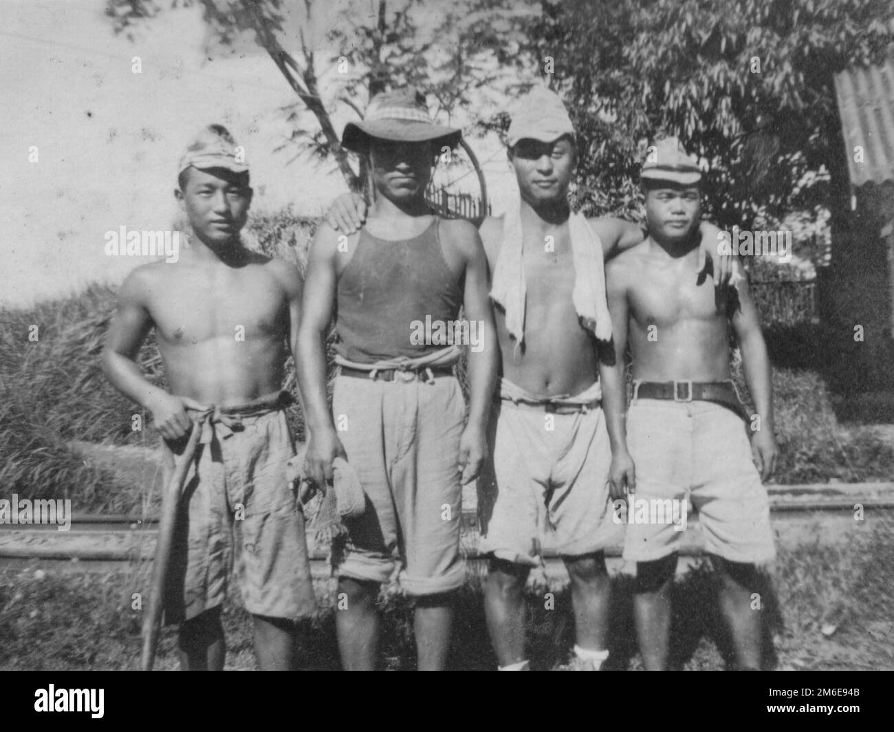 JAPANESE PRISONERS OF WAR. Former servicemen of the Imperial Japanese Military taken into custody by Allied authorities following Japan's capitulation and ordered to perform labor duties at Seletar Port, Singapore, are photographed in December 1946. These particular prisoners appear to be in relatively high spirits as their release from captivity and return home draws closer. Stock Photo