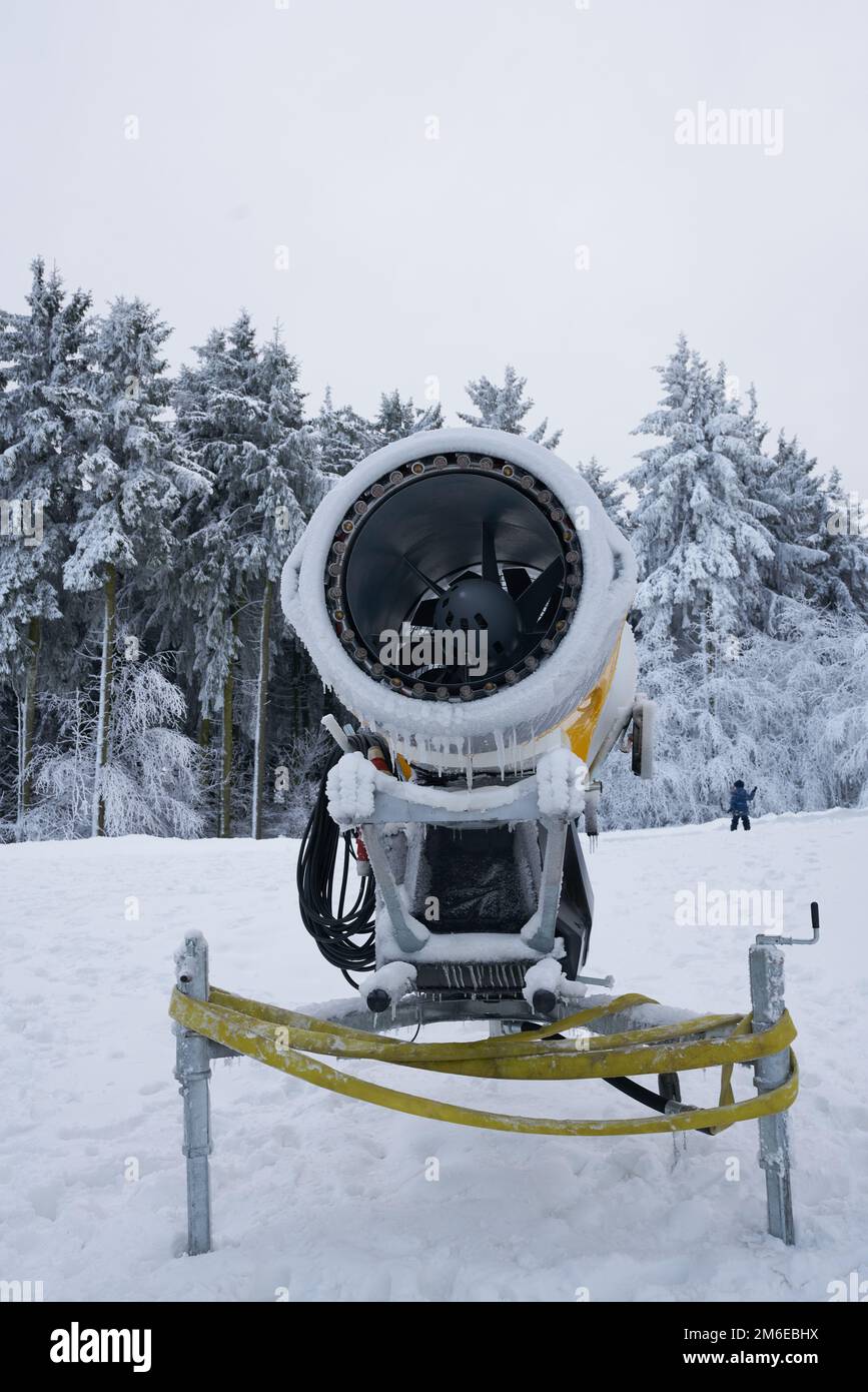 Yellow artificial snow cannon under snow on Wasserkuppe in Rhoen Hesse