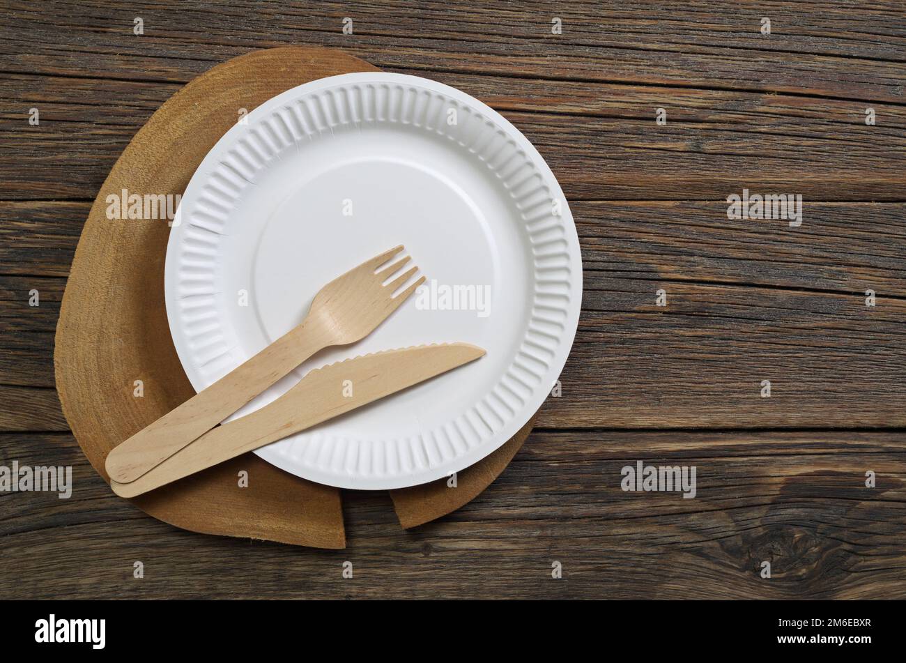 Paper plate with wooden knife and fork on old table, top view Stock ...