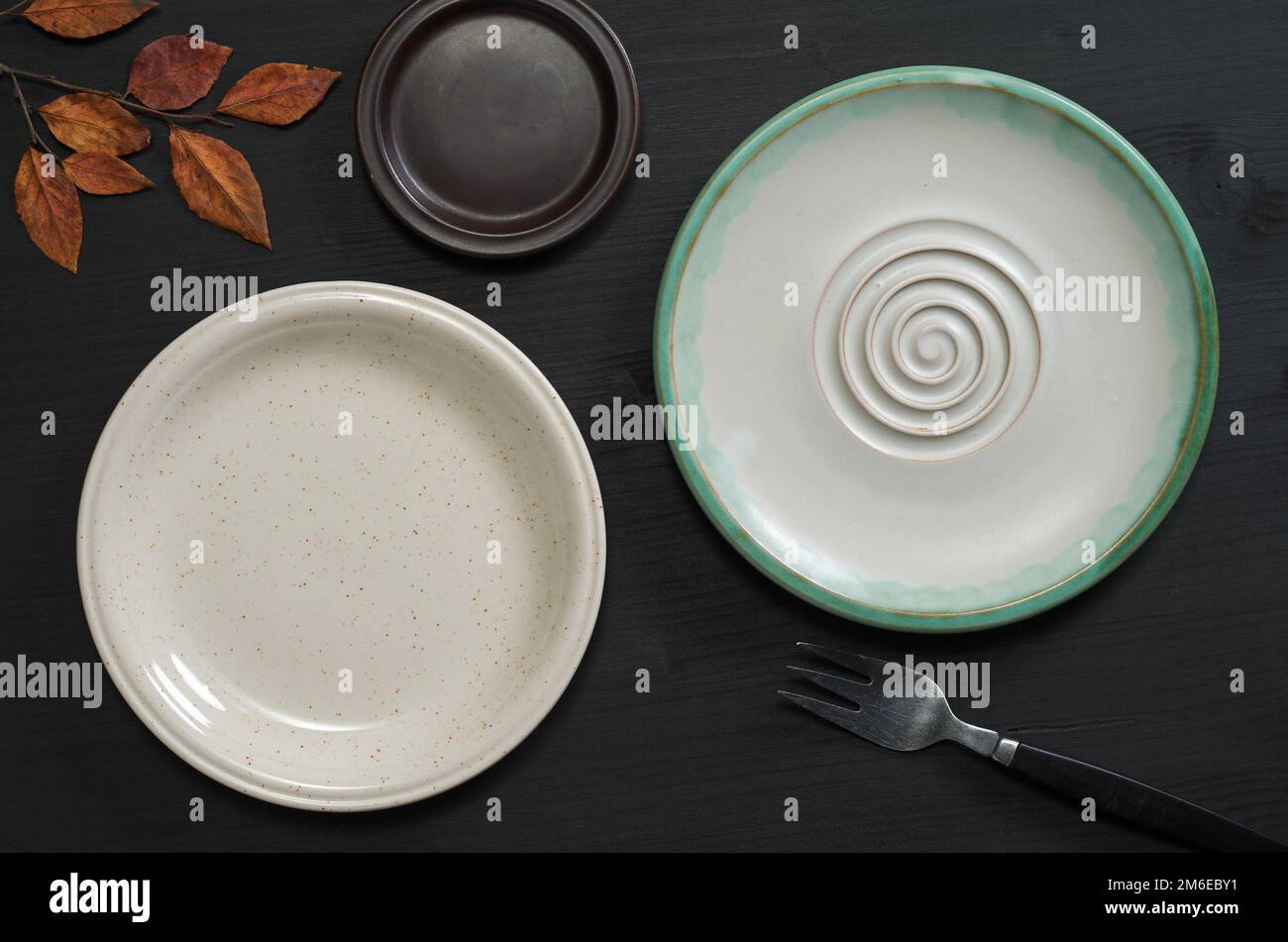 Various empty plates on black wooden table, top view Stock Photo