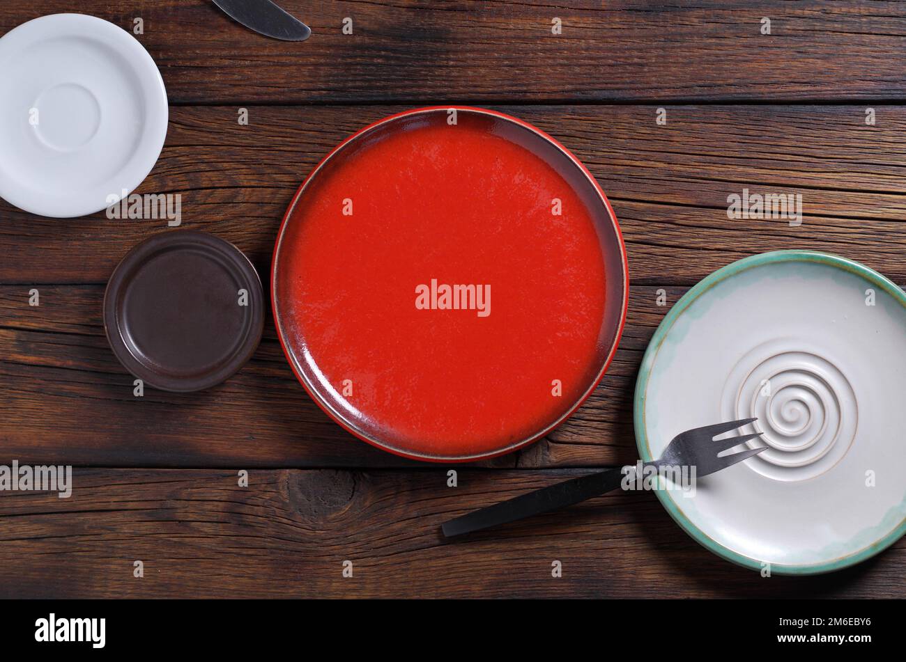 Various empty plates on dark wooden table, top view Stock Photo
