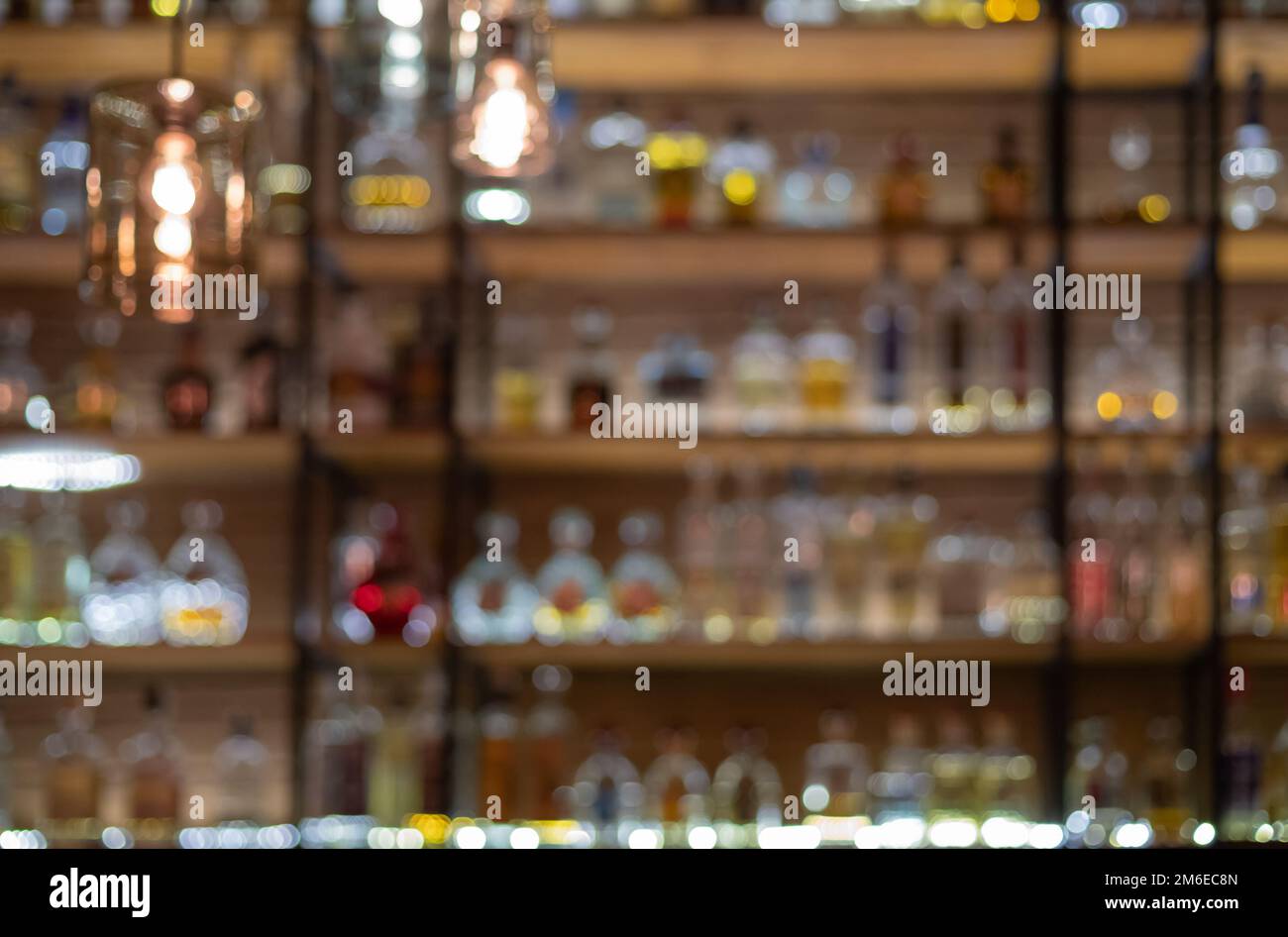 Defocused background of bar counter with various bottles of alcohol ...