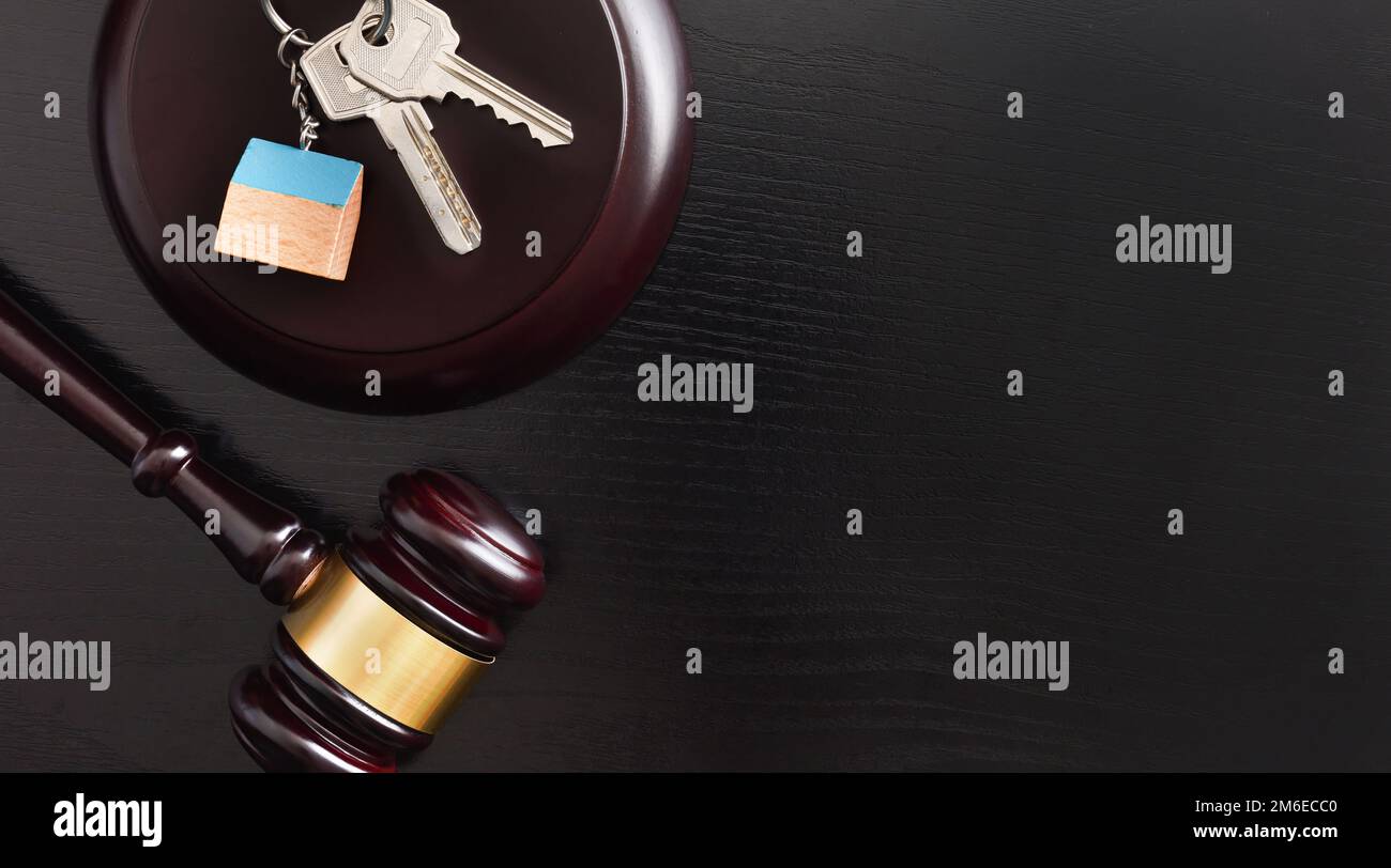 Housing reference judgment concept with house cutout and gavel on wooden table and black