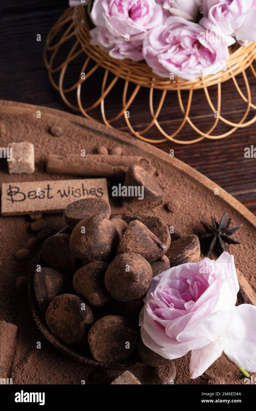 Delicious chocolate truffles around ingridients with pink rose bouquet. healthy sweets and present concept. Stock Photo