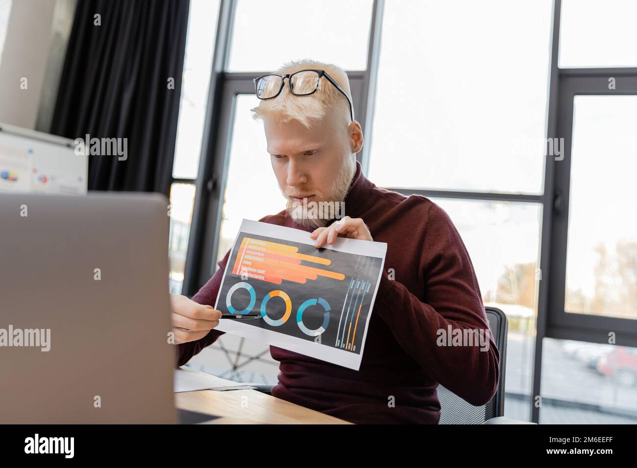 bearded albino businessman in glasses showing infographics during video call on laptop,stock image Stock Photo