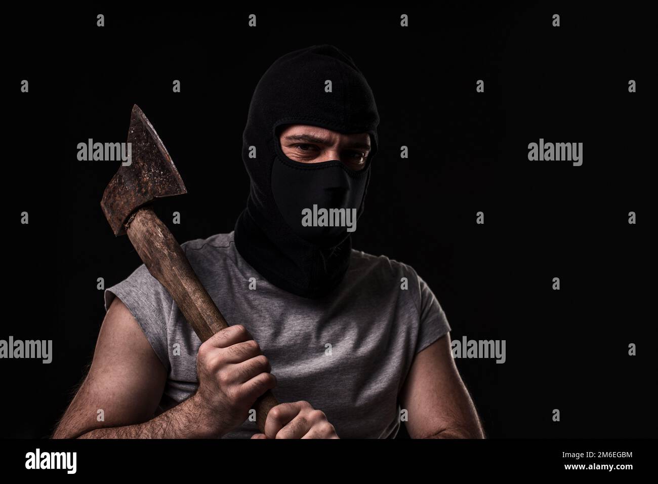 Bandit in black mask with hatchet on black background Stock Photo - Alamy