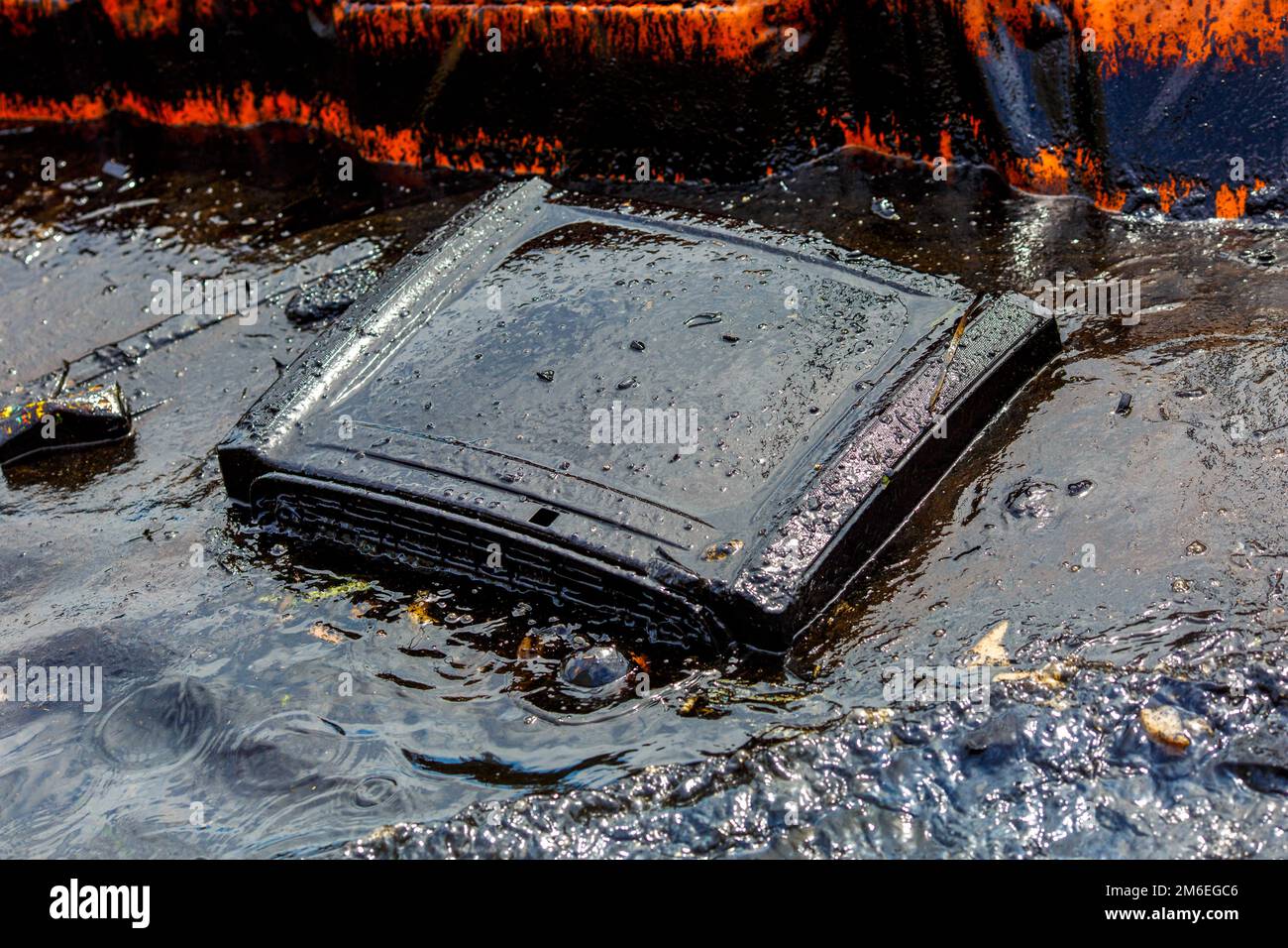 Ecological catastrophy. Close-up. Spill of oil products into the sea. Old TV floats in the oil-cover Stock Photo