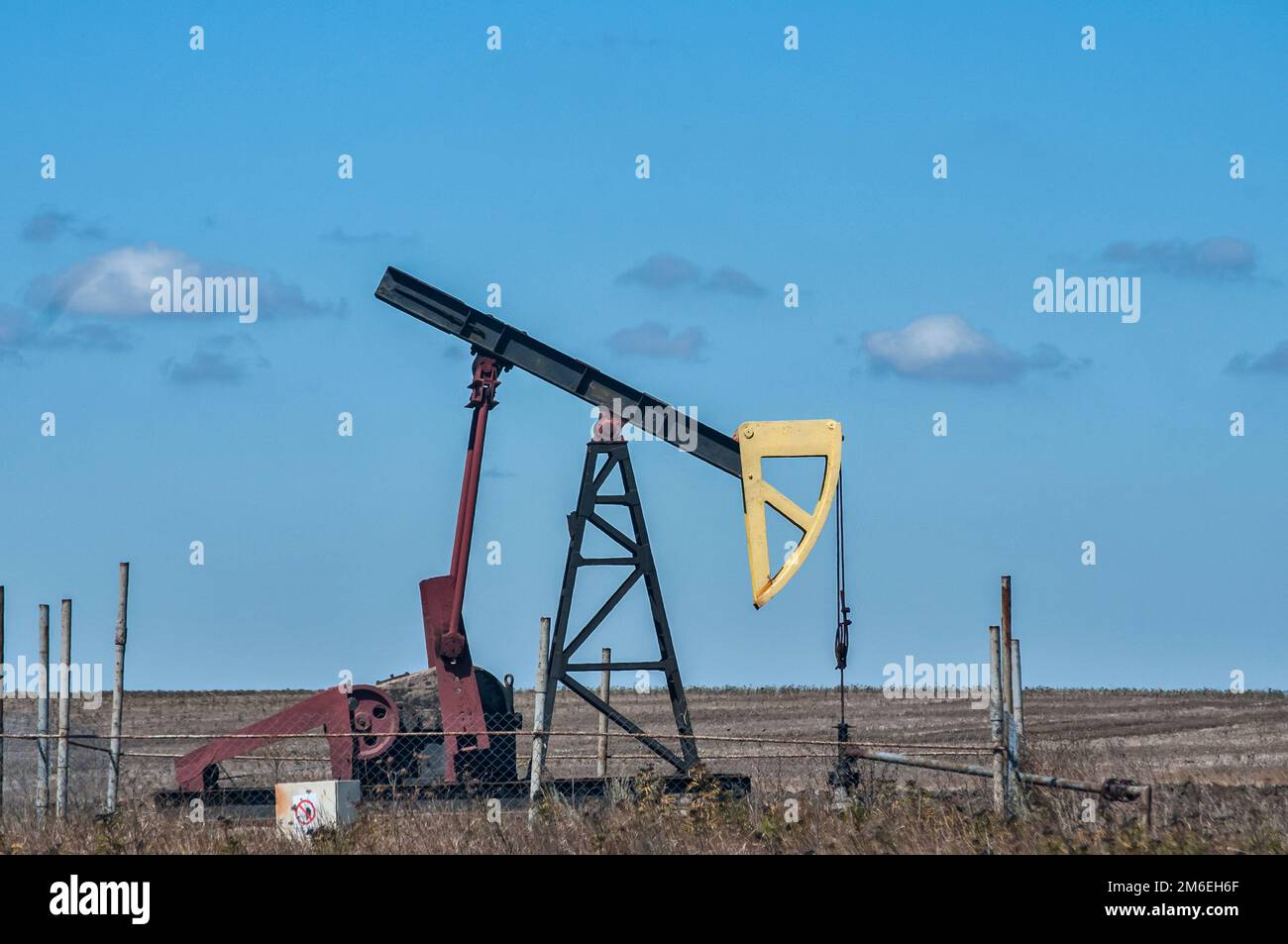 Opetating petrol oil well pump jack in summer sunny day Stock Photo