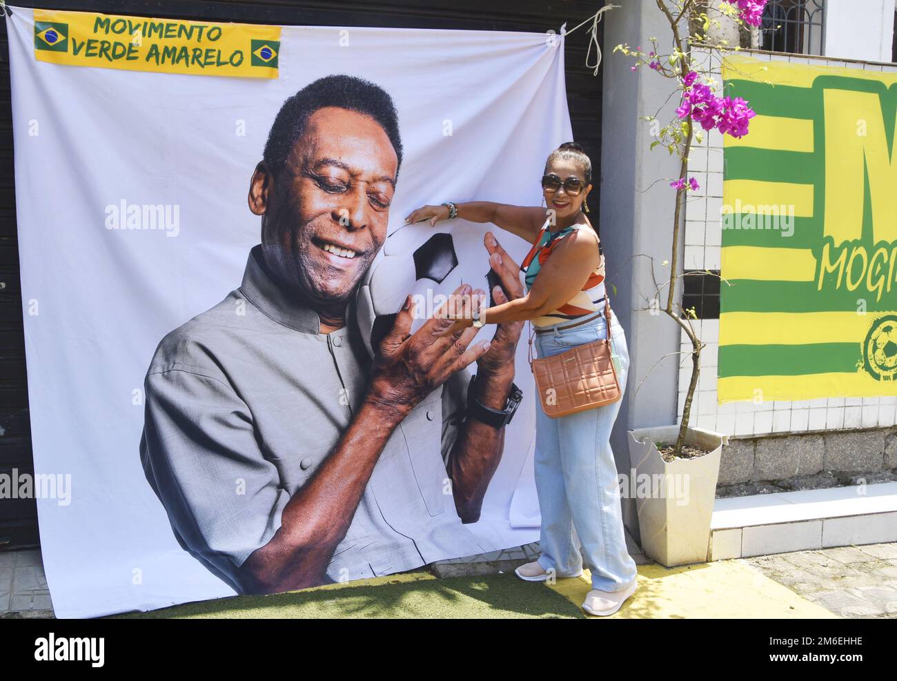 a-woman-poses-for-a-photo-in-front-of-a-cloth-printed-with-an-image-of