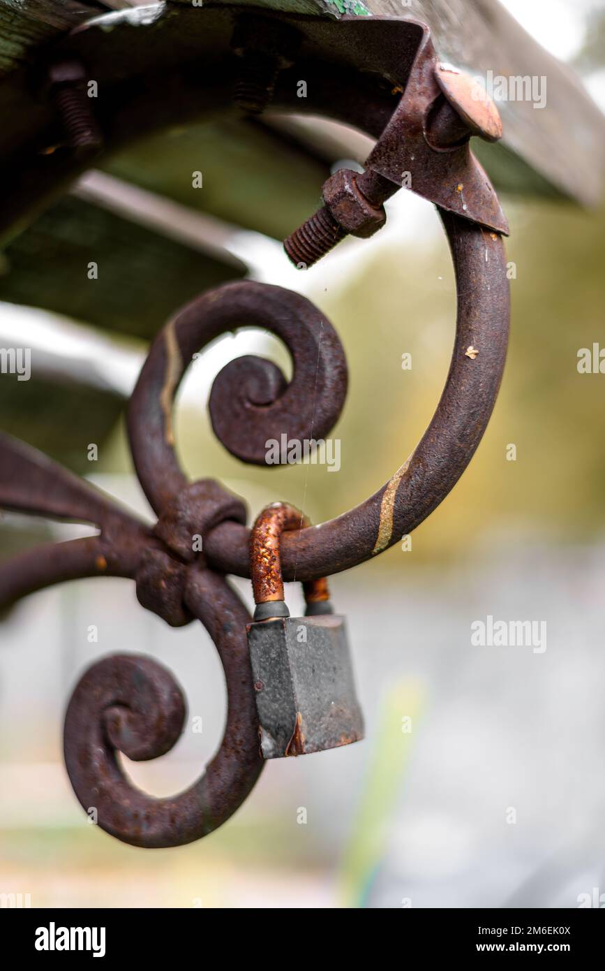 An old rusty lock hangs on a bench Stock Photo - Alamy