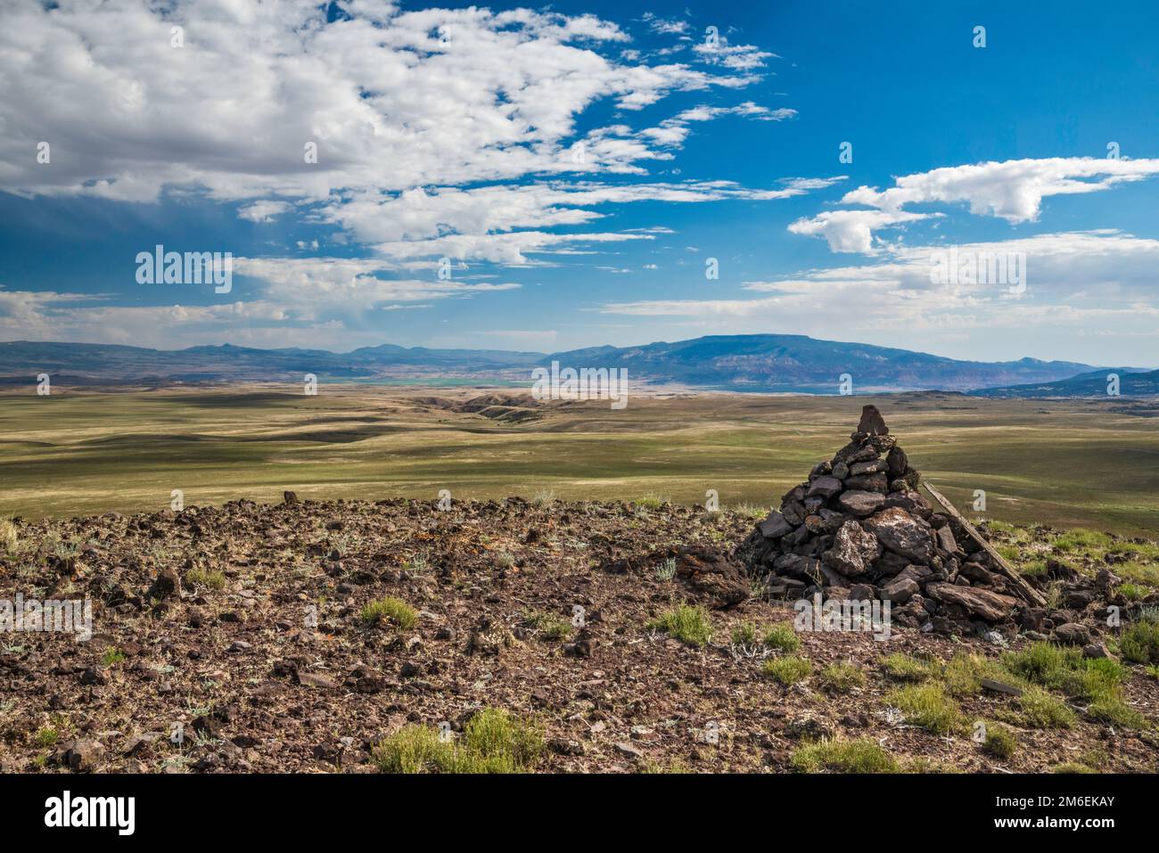 Rock cairn at Smooth Knoll, Fish Lake Mtns in distance, Awapa Plateau, Posey Lake Road (FR 154), near Bicknell, Utah, USA Stock Photo