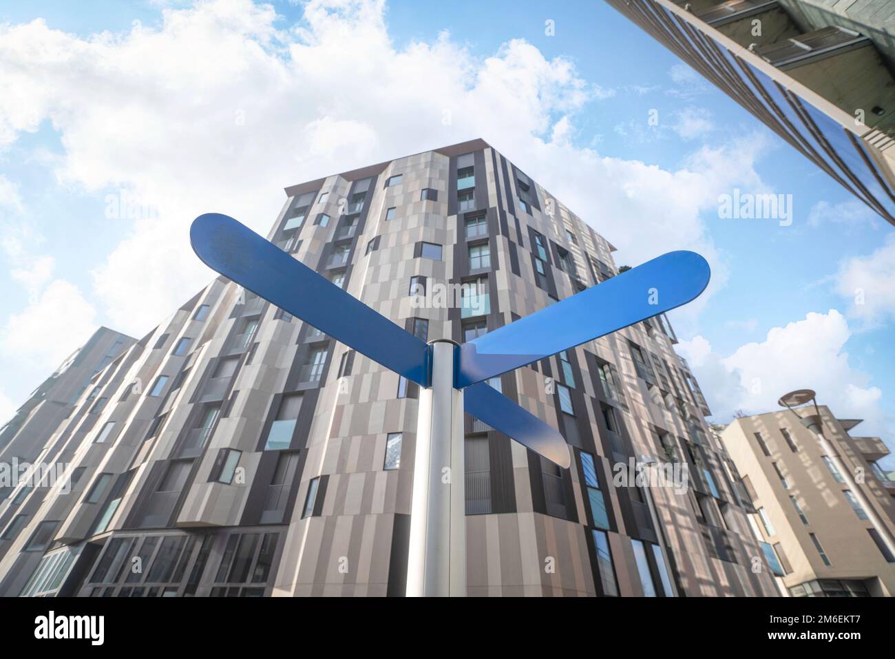 Street sign in a big city with a three way direction post and big ...