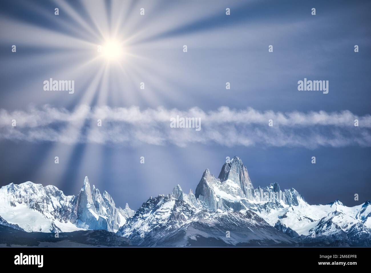 Mystical mountains with bright sun under a blue lighted sky Stock Photo