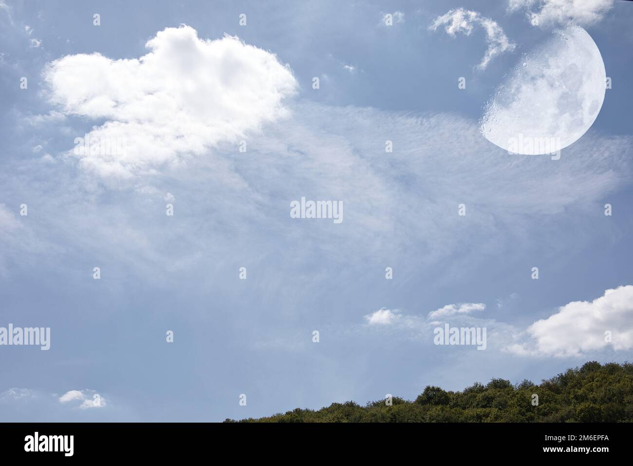 Cloud formations with moon in the blue summer sky Stock Photo