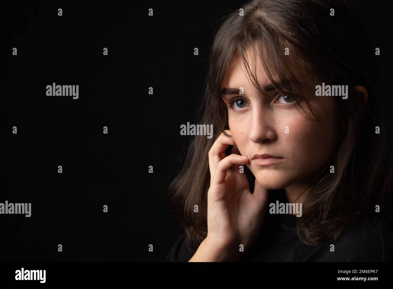 Psychological portrait of a beautiful young girl on a black background Stock Photo