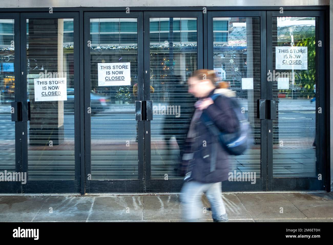 Shop closing down signs with motion blurred people on high street Stock