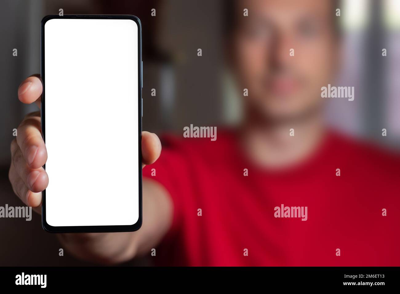 Man demonstrating smartphone with big blank white screen at camera. Man