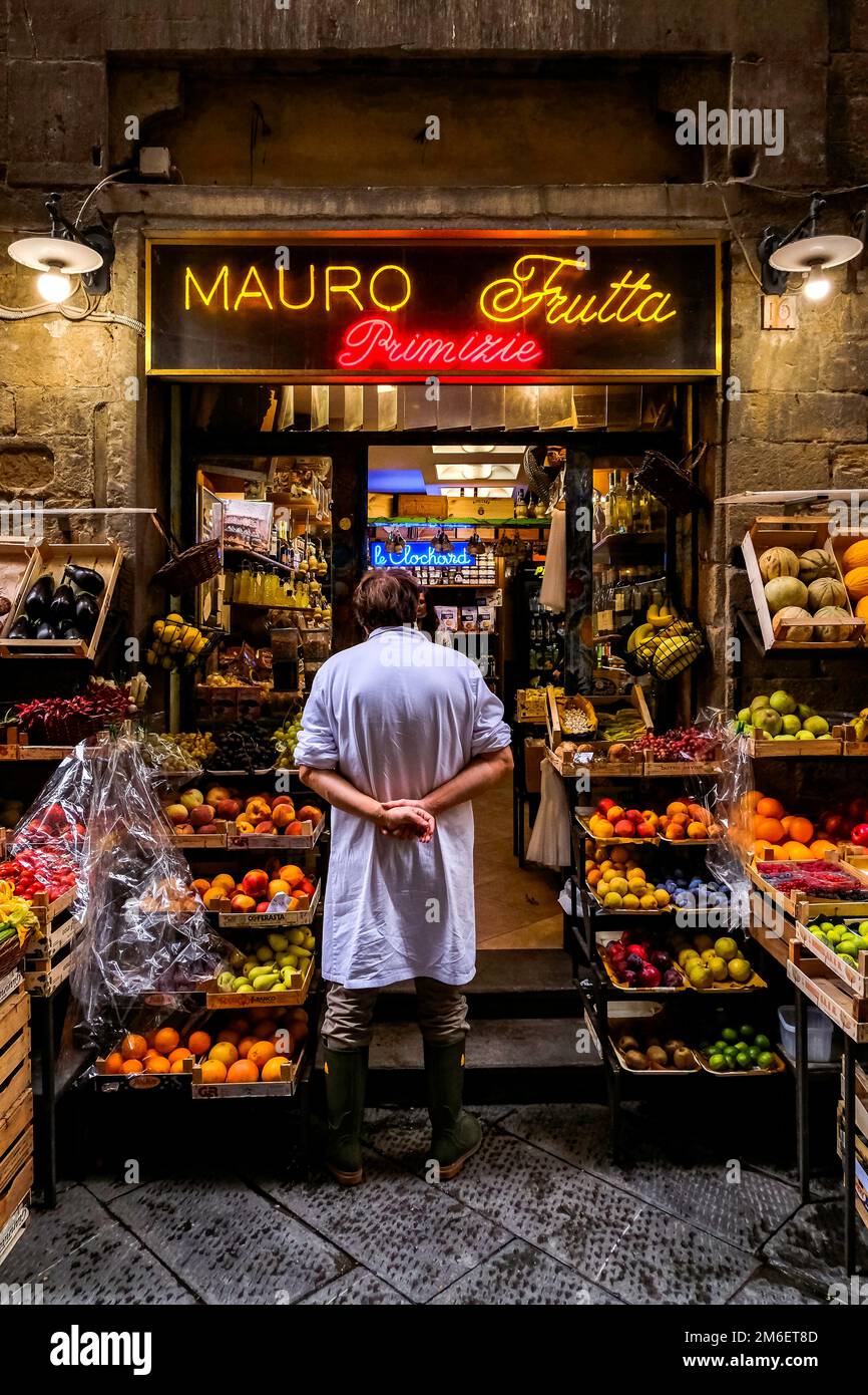 Salesman Standing in a Colorful Fruit Stand - Florence, Tuscany, Italy Stock Photo