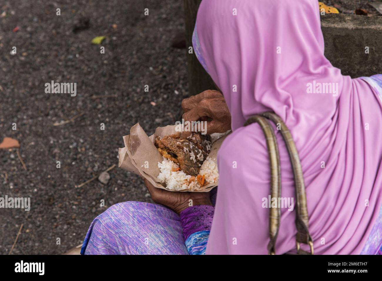 indonesian woman enjoying her lunch in the street. Stock Photo