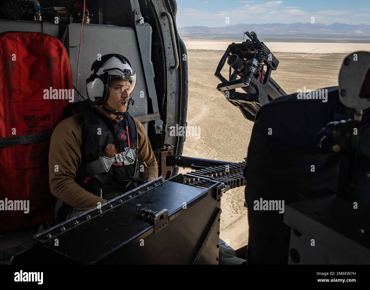 Naval Aircrewman (helicopter) 3rd Class Daniel Brito flies during a gun exercise with Helicopter Sea Combat Squadron (HSC) 5 at Naval Air Station Fallon, April 26, 2022. Carrier Air Wing (CVW) 7 is the offensive air and strike component of Carrier Strike Group (CSG) 10 and the George H.W. Bush CSG. The squadrons of CVW-7 are Strike Fighter Squadron (VFA) 143; VFA-103; VFA-86; VFA-136; Electronic Attack Squadron (VAQ) 140; Carrier Airborne Early Warning Squadron (VAW) 121; HSC-5; and Helicopter Maritime Strike Squadron (HSM) 46. Stock Photo