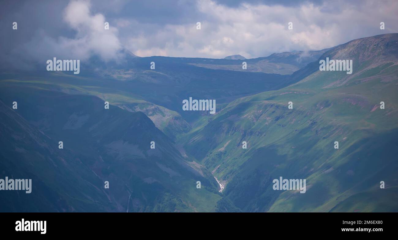 Mountains in clouds and clouds. Aerial view of a mountain peak with ...