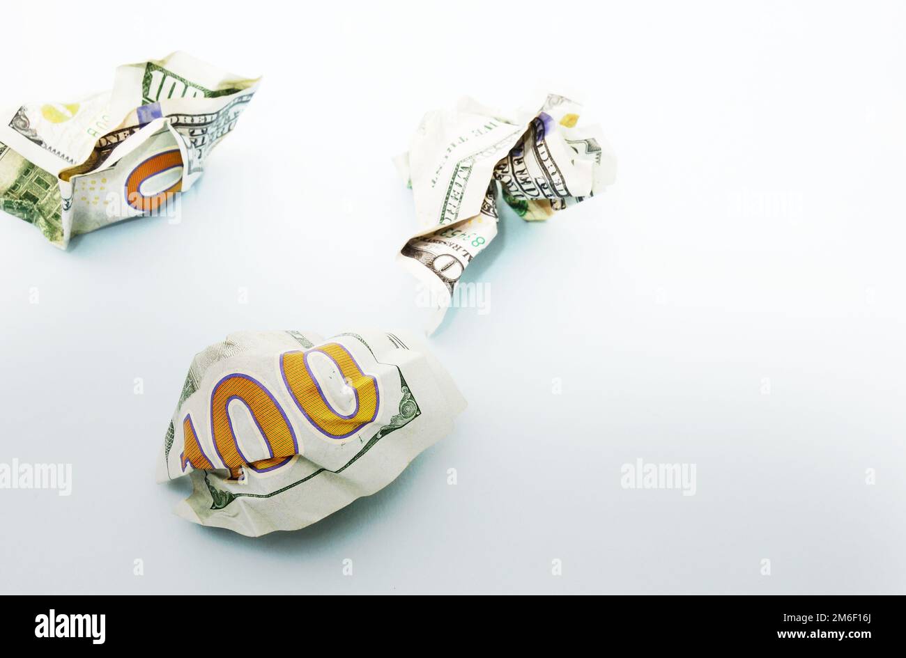 Crumpled hundred dollar bills on blue Stock Photo