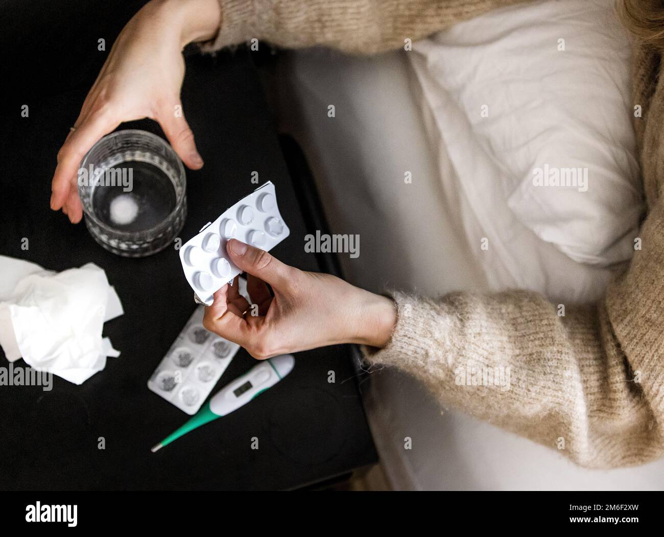 ILLUSTRATIVE - A woman takes paracetamol from bed. The number of people who report to their GP with flu-like symptoms is increasing. ANP REMKO DE WAAL netherlands out - belgium out Stock Photo