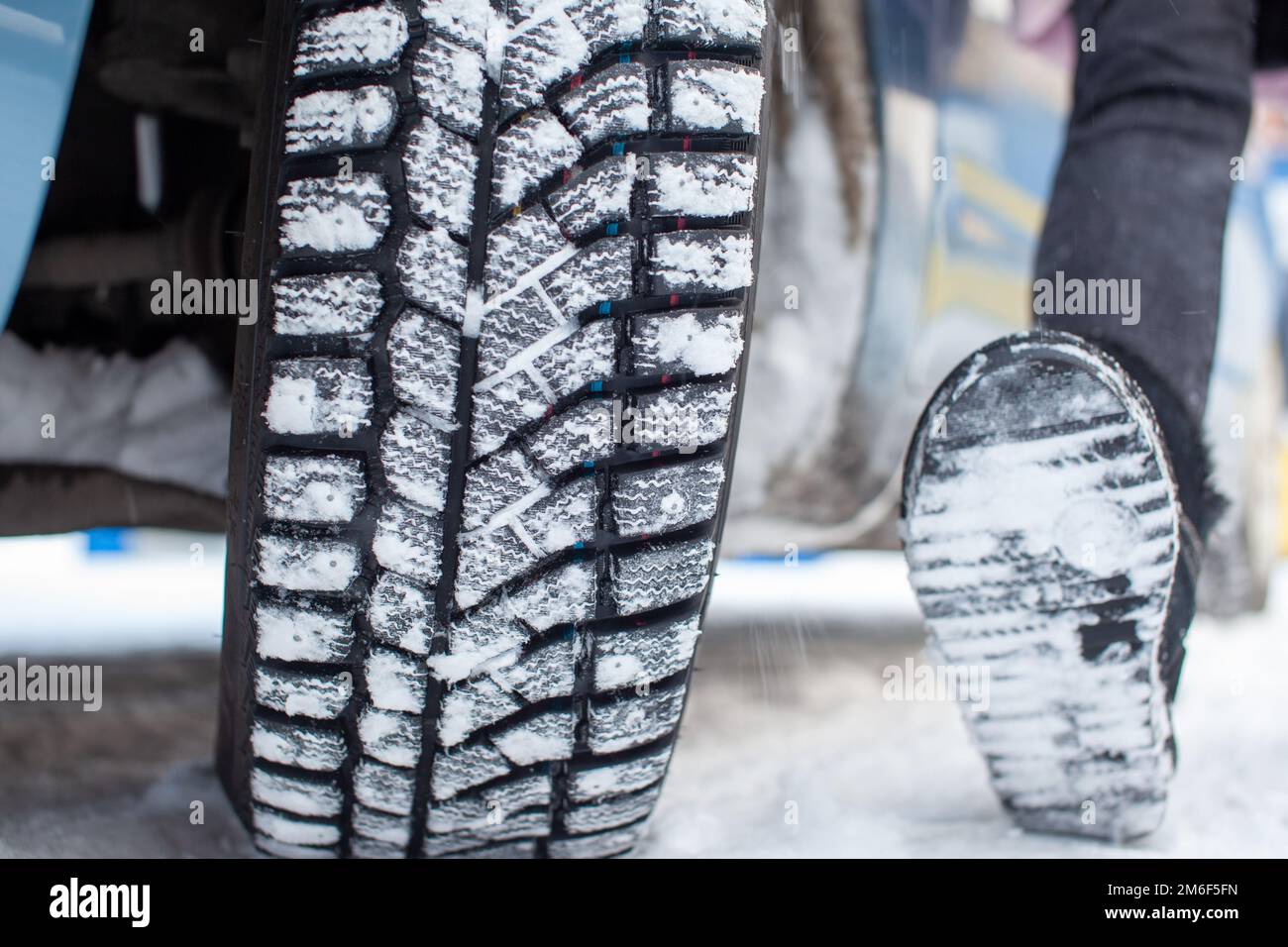 Car tires on the winter road are covered with snow. Stock Photo